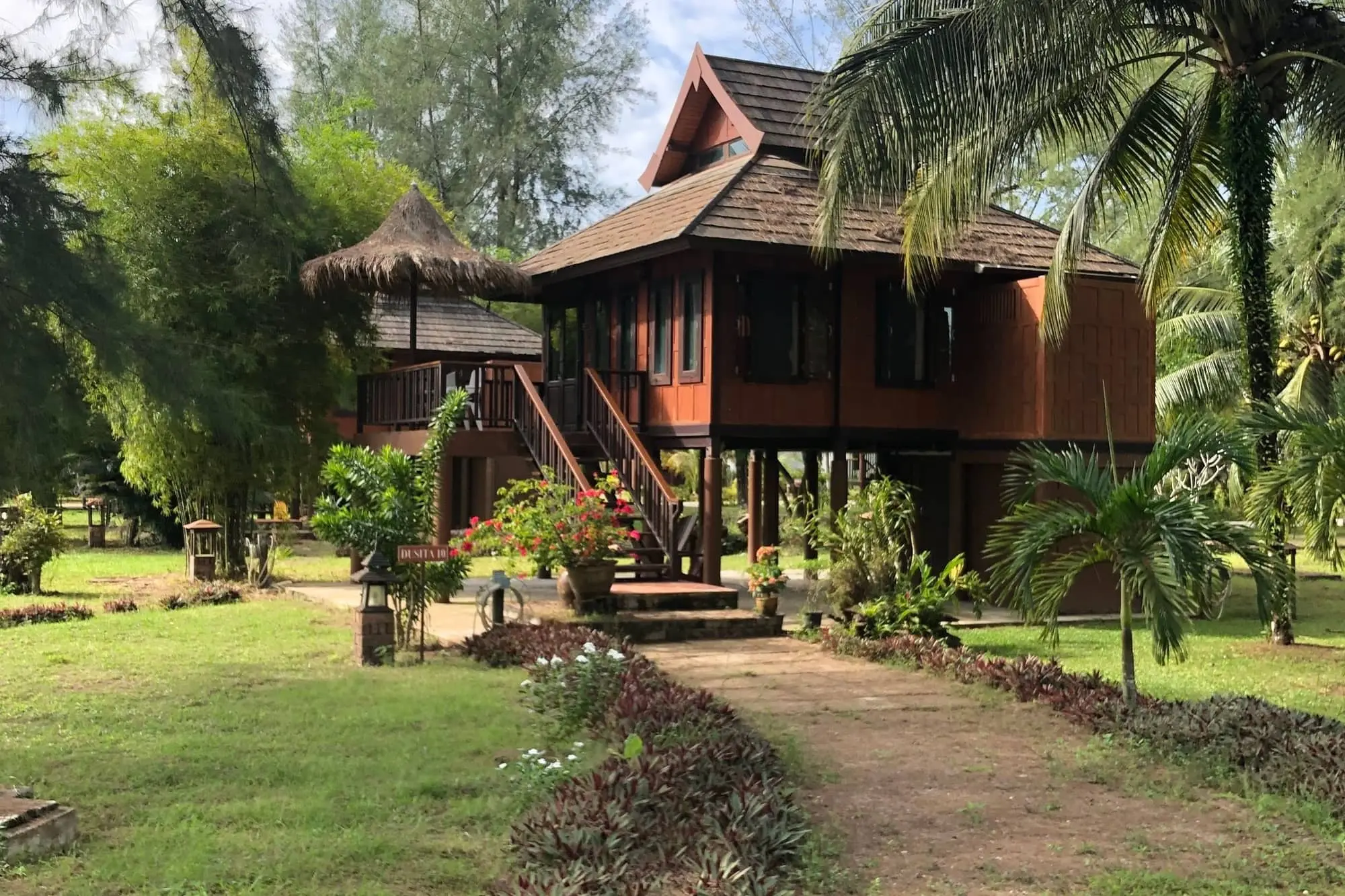 Traditional Thai wooden house on stilts in a tropical garden