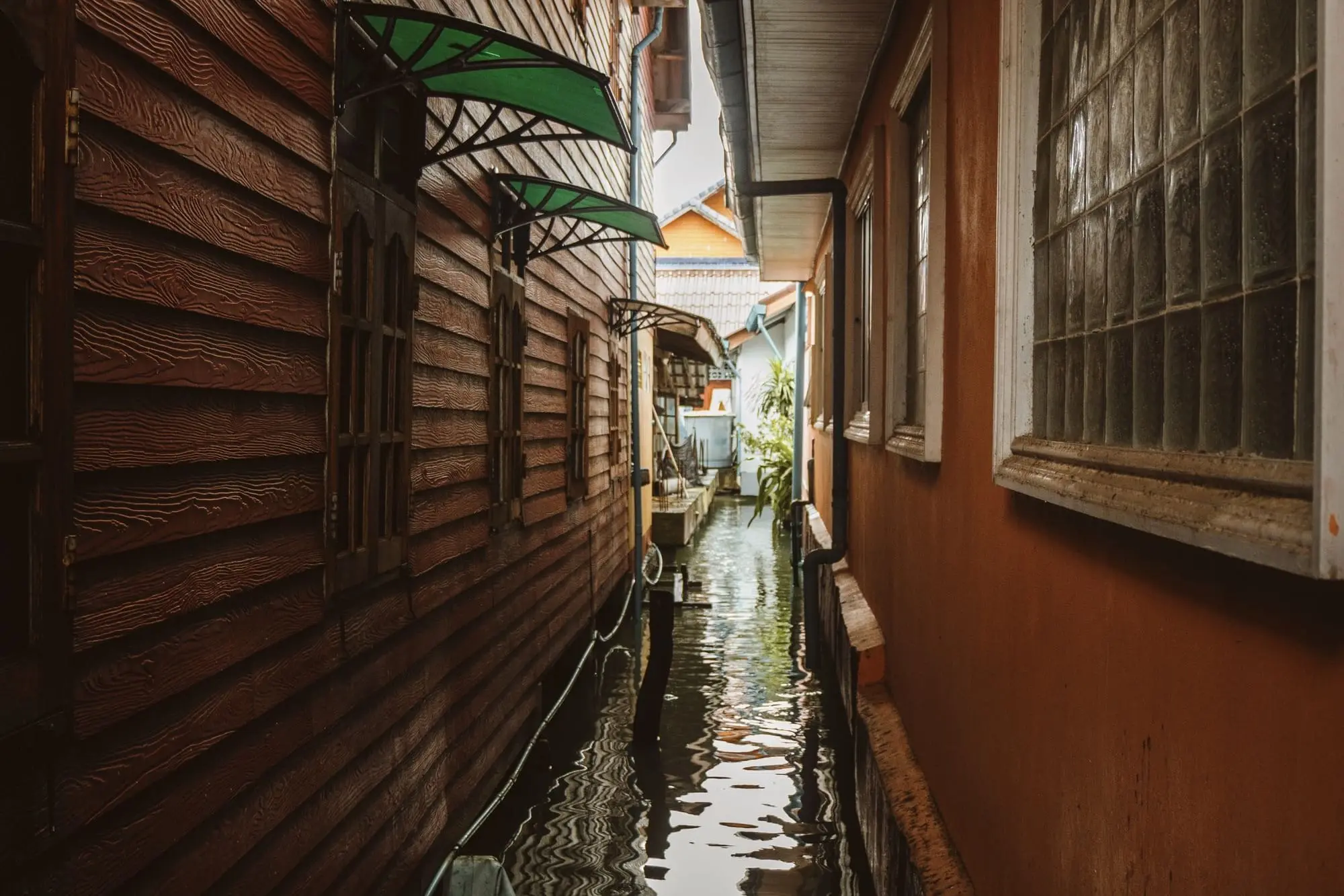 Flooded narrow alley between wooden houses in Surat Thani, Thailand