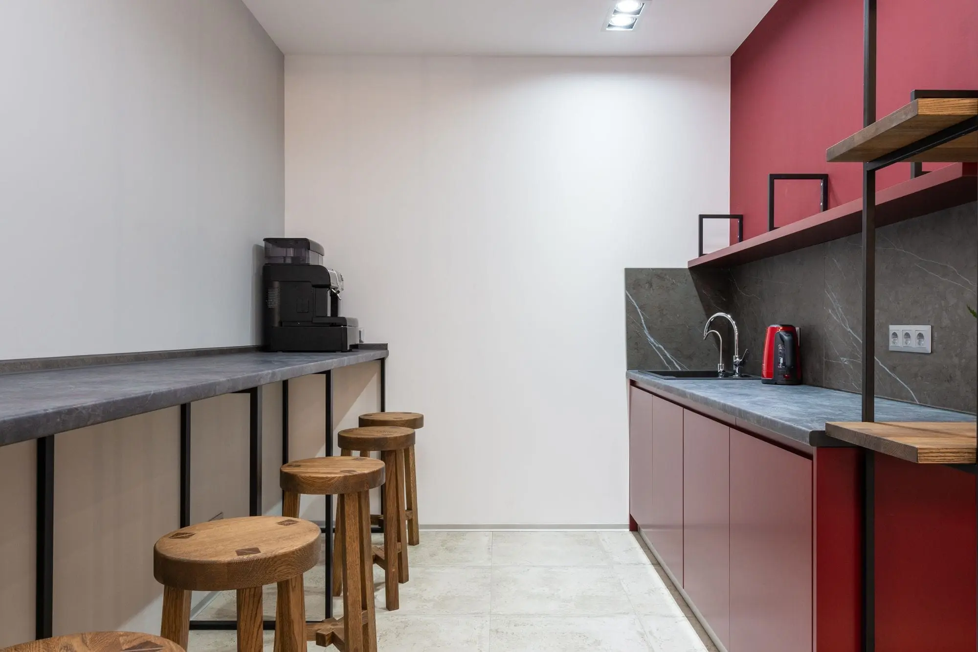 Modern office kitchen with a counter, stools and a sink