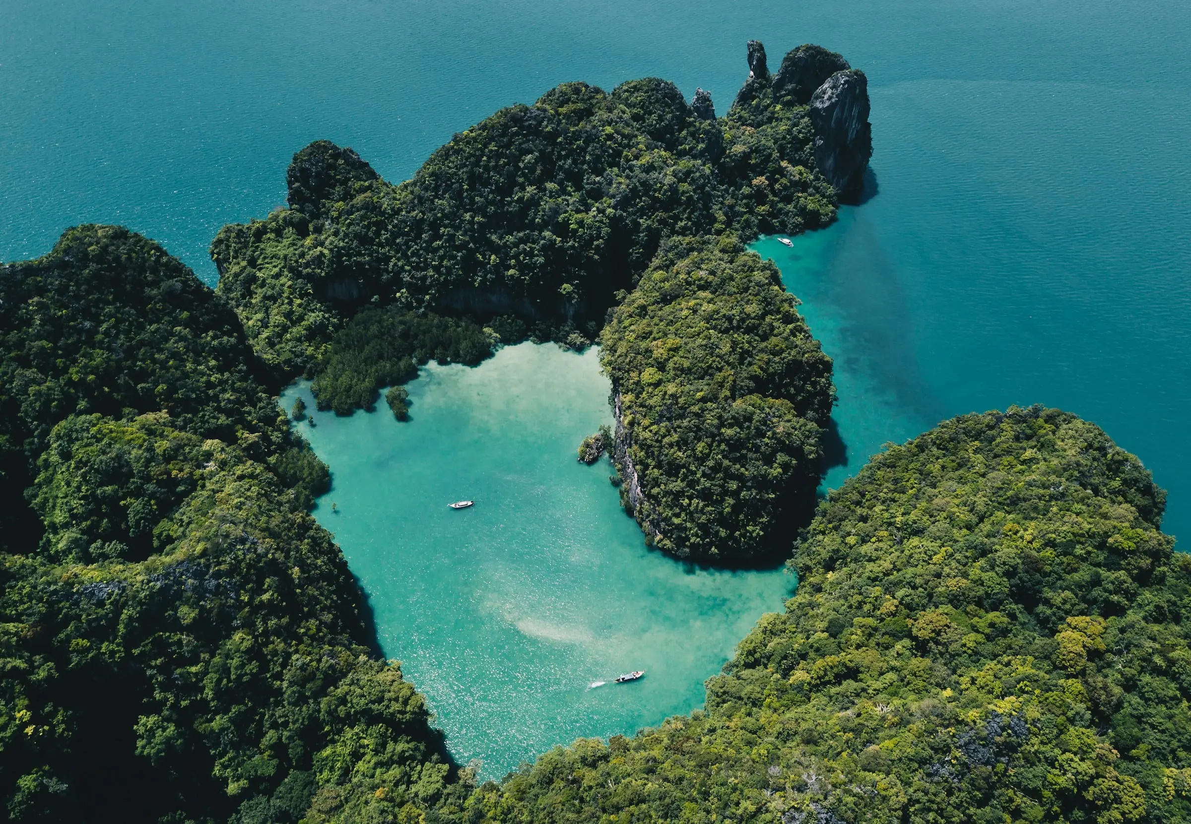 ภาพมุมสูงของหมู่เกาะที่ปกคลุมด้วยป่ากลางทะเลสีเทอร์ควอยซ์ ประเทศไทย